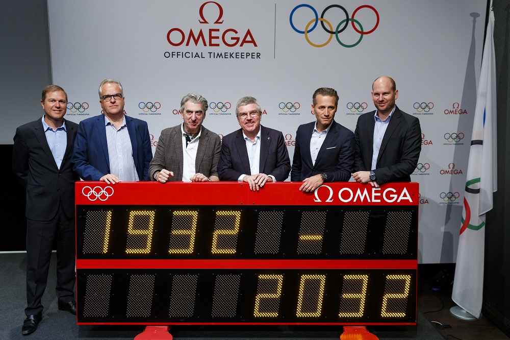 Swatch group and ioc executives highlight 100 years of omega working with the olympics.