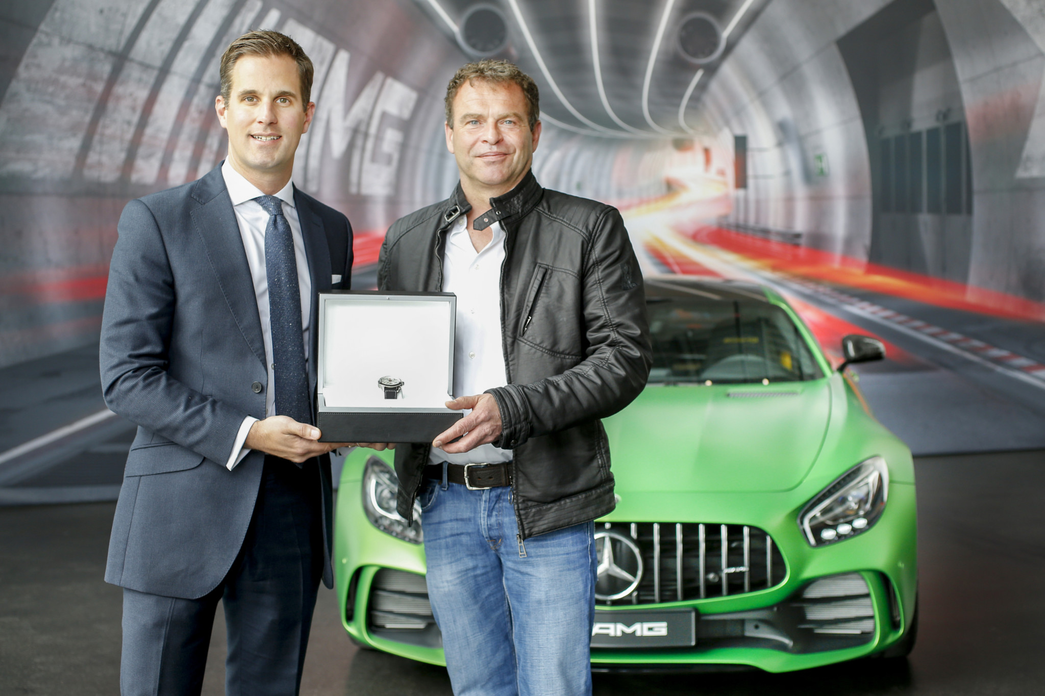 Iwc ceo christoph grainger-herr visits the amg manufacture in affalterbach and hands over the ingenieur chronograph sport edition "50th anniversary of mercedes-amg" to amg ceo tobias moers.