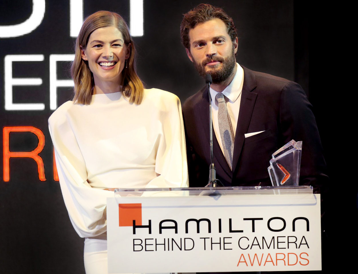 Hamilton behind the camera awards 2018 rosamund pike jamie dornan on stage 1 e1541670943431