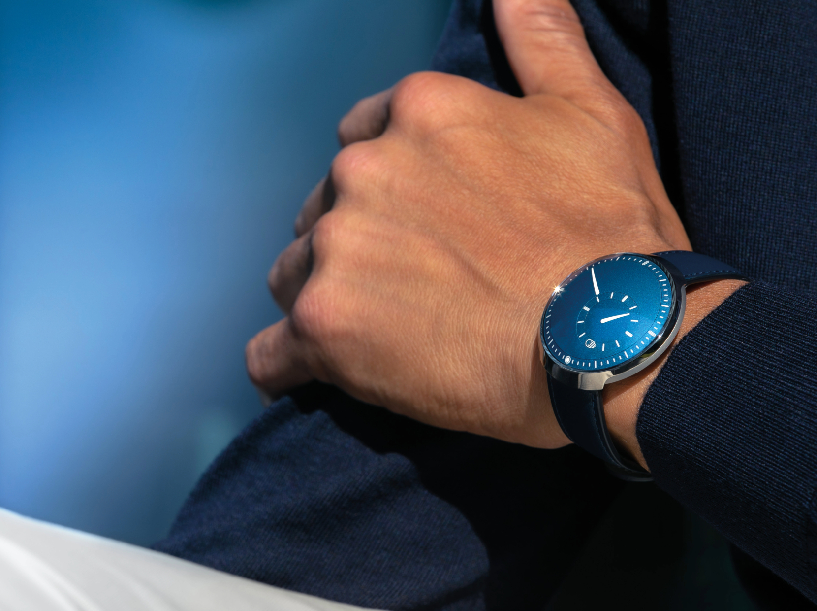 Ressence Type 8 Cobalt Blue on the wrist against a dark blue jacket